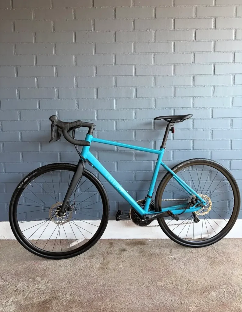 Triban RC 500 bleu vu de profil, avec fourche carbone et freins à disque, après 3 000 km de test